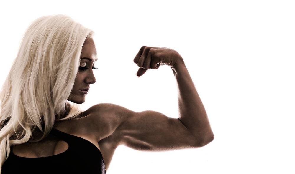 strong lean woman flexing bicep